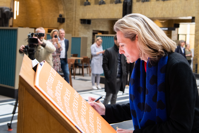 911035 Afbeelding van wethouder Anke Klein die in het gastenboek van de Bibliotheek Neude (Neude 11) te Utrecht ...